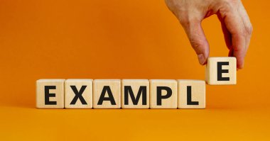 Örnek sembol. Ahşap küplerle ilgili konsept kelime. Güzel turuncu masa, turuncu arka plan, fotokopi alanı. İşadamı eli. İş ve örnek kavram.