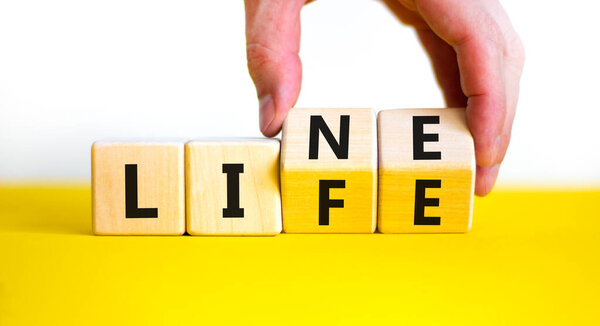Lifeline, line of life symbol. Businessman hand turns cubes and changes the word 'life' to 'line'. Beautiful white background. Business lifeline, line of life concept. Copy space.