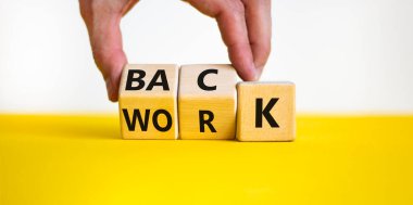 Back to work symbol. Businessman turns wooden cubes and changes the word back to work. Beautiful yellow table, white background, copy space. Business and back to work covid-19 pandemic concept.