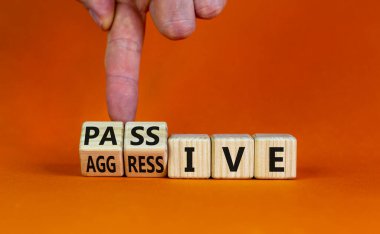 Pasif ya da agresif sembol. İş adamı ahşap küplere dönüşür ve pasif kelimesini agresifliğe çevirir. Güzel turuncu arkaplan, kopyalama alanı. İş, psikolojik pasif agresif konsept.