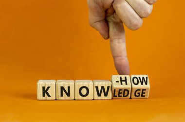 Knowledge and know-how symbol. Businessman turns cubes, changes the word know-how to knowledge. Beautiful orange background, copy space. Business, knowledge and know-how concept.