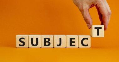 Konu sembolü. Ahşap küplerdeki konsept kelime. Güzel turuncu masa, turuncu arka plan, fotokopi alanı. İşadamı eli. İş ve konu kavramı.