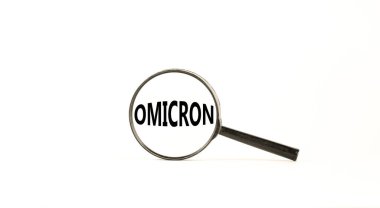 Covid-19 Corona ve Omicron sembolü. Konsept kelime Omicron. Büyüteç. Güzel beyaz masa, beyaz arka plan. Tıbbi covid-19 Corona omicron konsepti. Boşluğu kopyala.