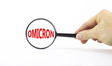 Covid-19 Corona ve Omicron sembolü. Konsept kelime Omicron. Büyüteç. Doktor eli. Güzel beyaz masa, beyaz arka plan. Tıbbi covid-19 Corona omicron konsepti. Boşluğu kopyala.