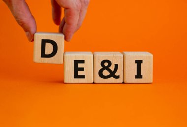 DEI, Çeşitlilik, sermaye ve kapsama sembolü. DEI, çeşitlilik, özsermaye ve güzel turuncu arka planda tahta küplere eklenen kavramsal kelimeler. İş, DEI, çeşitlilik, sermaye ve kapsama kavramı.