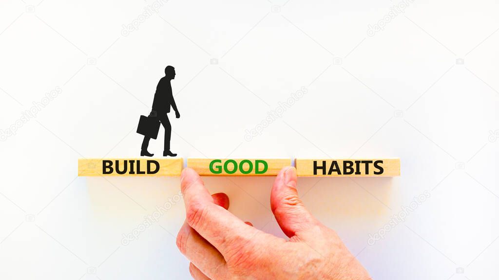Build good habits symbol. Concept words Build good habits on wooden blocks on beautiful white table white background. Businessman hand. Copy space. Business, psychological build good habits concept.