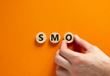 SMO, sosyal medya optimizasyon sembolü. SMO kavramını ele alalım. Sosyal medya, güzel turuncu arka planda ahşap daireler üzerine optimizasyon, kopyalama alanı. İş, SMO - sosyal medya optimizasyon kavramı.
