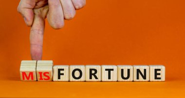 Şans ya da talihsizlik sembolü. İşadamı tahta küpleri değiştiriyor ve talihsizlik kavramını servete çeviriyor. Güzel turuncu arkaplan, kopyalama alanı. İş, servet veya şanssızlık konsepti.