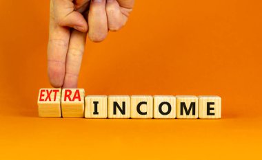 Fazladan gelir sembolü. İşadamı tahta küpleri değiştiriyor ve konsept kelimeleri geliri ekstra gelire dönüştürüyor. Güzel turuncu masa, turuncu arka plan fotokopi alanı. İş ve ekstra gelir kavramı.