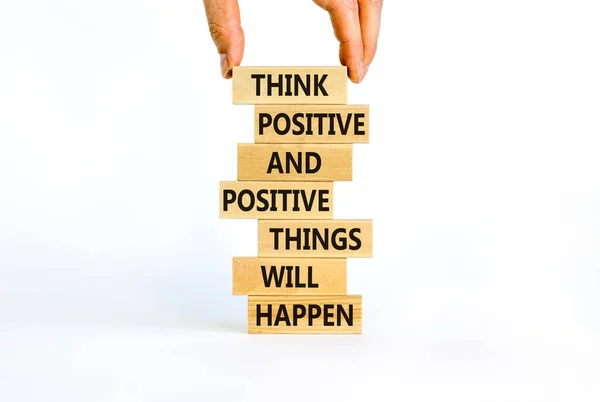 Think positive symbol. Wooden blocks with words Think positive and positive things will happen. Beautiful white background, copy space. Businessman hand. Business, motivational think positive concept.