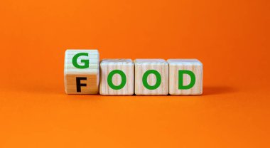 Güzel yemek sembolü. Tahta küplere dönüştü ve Gıda kelimesini İyiye çevirdi. Güzel turuncu masa arkaplanı. Yaşam tarzı, sağlıklı beslenme ve iyi yemek konsepti, kopyalama alanı.
