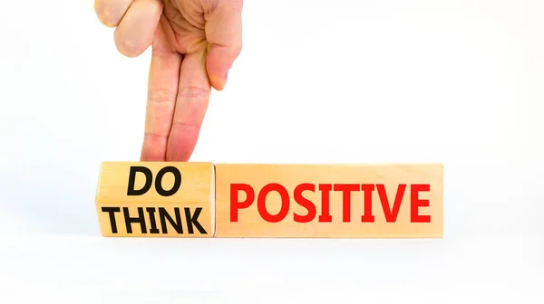 Think and do positive symbol. Businessman turns wooden cubes and changes words think positive to do positive. Beautiful white background. Business, think and do positive concept. Copy space.