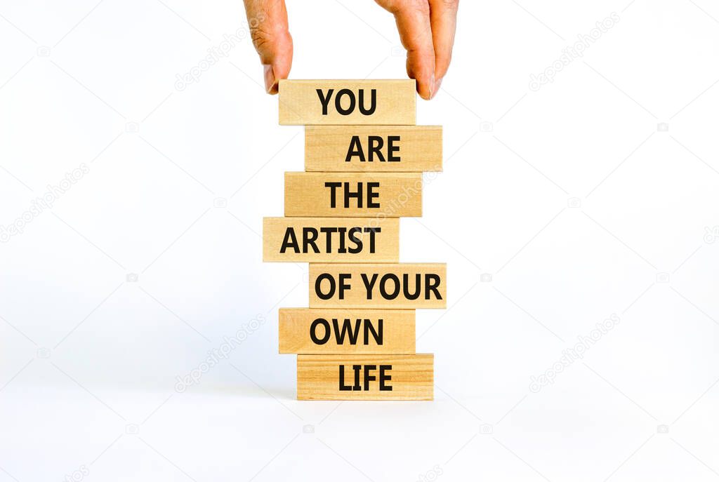 You artist of your life symbol. Wooden blocks with words You are the artist of your own life. Beautiful white background, copy space. Businessman hand. Business, motivational lifestyle concept.