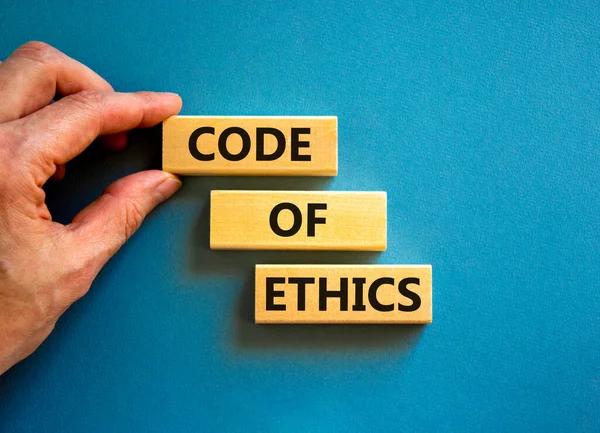 倫理記号のコード コンセプトワード美しい青いテーブルの青の背景に木製のブロック上の倫理コード ビジネスマンの手だ ビジネスと倫理的概念のコード スペースのコピー — ストック写真