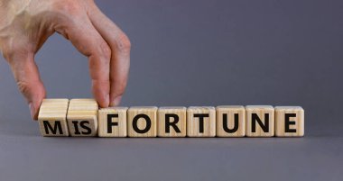 Şans ya da talihsizlik sembolü. İşadamı tahta küpleri değiştiriyor ve talihsizlik kavramını servete çeviriyor. Güzel gri arkaplan, kopyalama alanı. İş, servet veya şanssızlık konsepti.