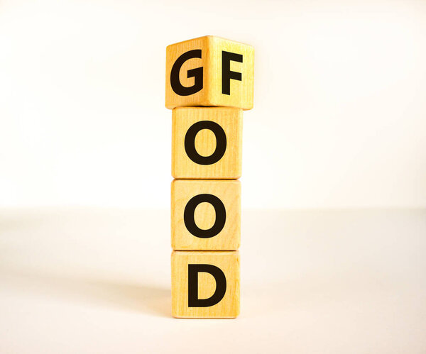 Good food symbol. Turned wooden cubes and changed the word Food to Good. Beautiful white table white background. Lifestyle, healthy eating and good food concept, copy space.