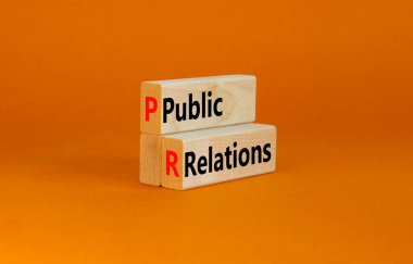 Halkla ilişkiler sembolü. Kavramsal kelimeler Halkla İlişkiler tahta bloklar üzerinde turuncu masa arka planı, kopyalama alanı. İş ve Halkla İlişkiler kavramı.