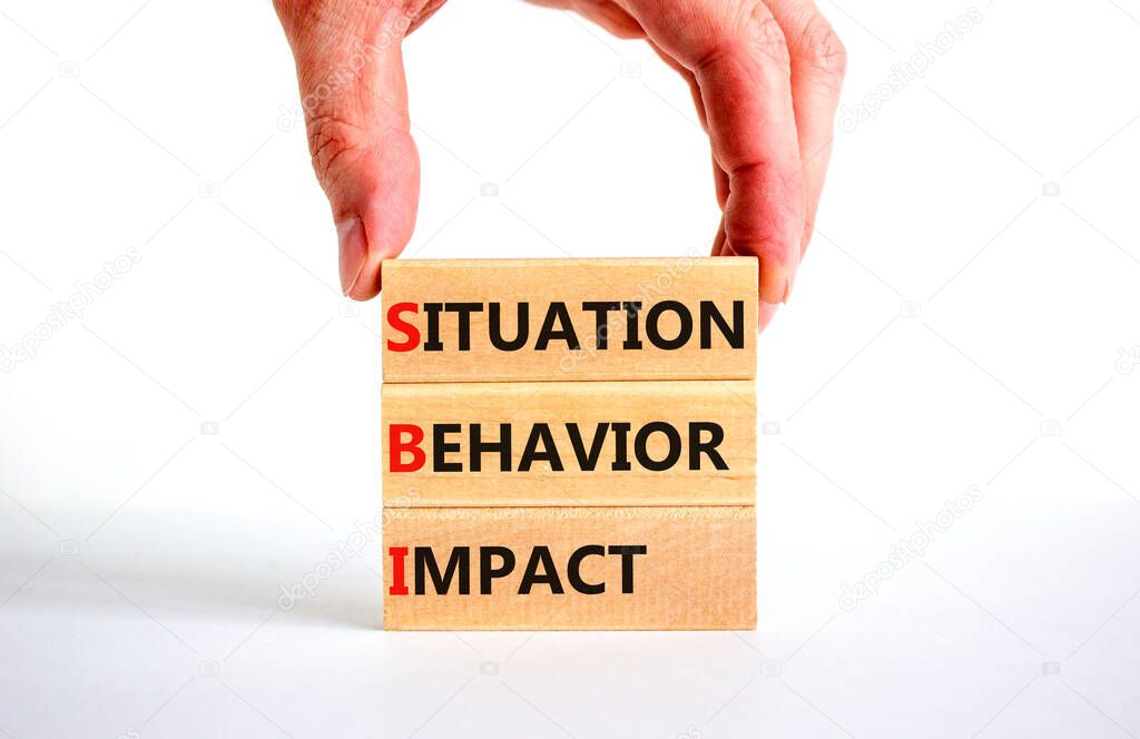 SBI situation behavior impact symbol. Concept words SBI situation behavior impact on blocks on a white background. Psychologist hand. Psychological SBI situation behavior impact concept. Copy space.