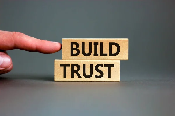 树立信任的象征 概念词在漂亮的灰色桌子灰色背景上的木块上建立信任 商人的手 业务和建立信任概念 复制空间 — 图库照片