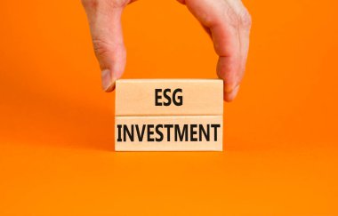 ESG Çevre Yönetimi Yatırım Sembolü. Güzel bir turuncu arka planda bloklara ESG yatırımı kavramı. İşadamı eli. İş, ESG yatırım konsepti. Boşluğu kopyala.