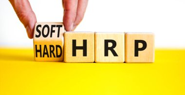 HRP, insan kaynakları planlama sembolü. İşadamı ahşap küpü değiştirip sert HRP 'yi yumuşak HRP' ye çeviriyor. Güzel beyaz arka plan. İş, HRP, insan kaynakları planlaması. Boşluğu kopyala.