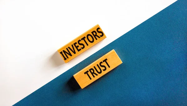 投資家はシンボルを信頼する コンセプトワード投資家は美しい青いテーブルの白い背景に木製のブロックを信頼しています ビジネス投資家と投資家の信頼の概念 コピースペース — ストック写真