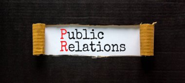 Halkla ilişkiler sembolü. Beyaz kağıt üzerinde halkla ilişkiler kavramları. Güzel siyah arka plan. Uzayı kopyala İş ve Halkla İlişkiler kavramı.