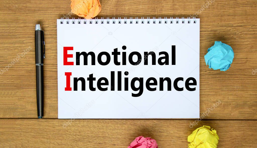 EI emotional intelligence symbol. Concept words EI emotional intelligence on white note. Metallic pen. Beautiful wooden background. Business EI emotional intelligence concept, copy space.