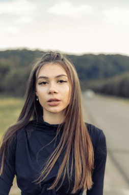 Siyah saçlı, güzel bir genç kızın portresi. Elinde kare olan kız kameraya bakıyor. Temiz cilt. cilt bakımı