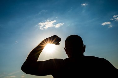 Bulutlu mavi bir arka planda genç adamın güçlü gövdesi.