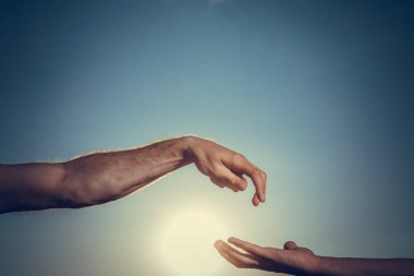 Yardım eli uzatıyorum. Mavi bulutlu gökyüzüne uzanan iki el.