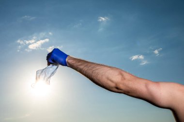 Mavi gökyüzüne karşı koruyucu bir maske ve steteskop tutan bir tıp doktoru. Coronavirus covid-19 enfeksiyonu.