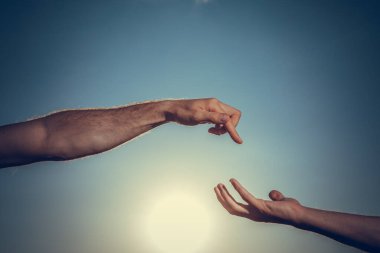 Yardım eli uzatıyorum. Mavi bulutlu gökyüzüne uzanan iki el.