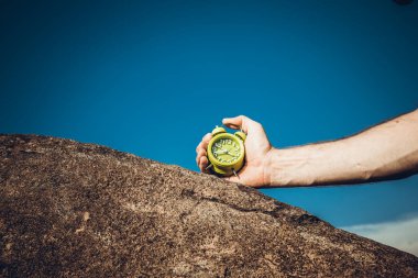 Mavi arkaplanda yeşil alarmlı saati tutan kadın, görüntüyü kapat.