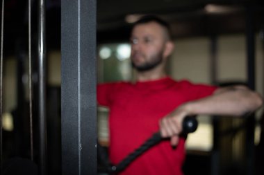 Spor salonunda egzersiz yapan yakışıklı bir genç..