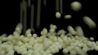 Küçük çikolata topları siyah arkaplandan aşağı düşüyor.