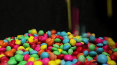 Siyah arka planda düşen renkli çikolata