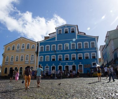 Largo do Pelourinho ve Rosrios dos Pretos Kilisesi 'nin manzarası ve Salvador Bahia' da güneşli bir günde birkaç turist.