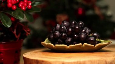 Arka planda Noel ışıkları olan bir kasede harika bir üzüm demeti..