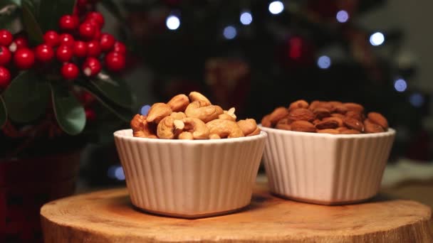 Zwei Schalen Voller Nüsse Mit Weihnachtsbeleuchtung Hintergrund — Stockvideo