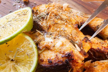 Tahta masada portakal ve biberiyeli kızarmış balık dilimleri.