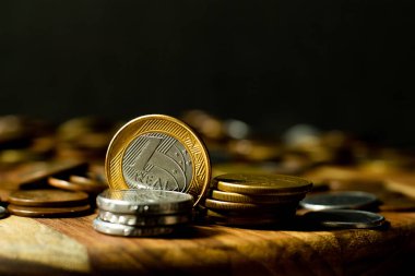 Siyah arka planı olan madeni paralar için çevrili Brezilya gerçek sikkelerinden birinin kopyası.