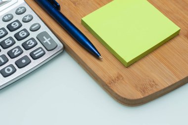 Hesap makinesi beyaz masanın altında not defterinin yanında - ofis