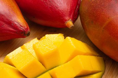 delicious piece of mango cut into cubes with fruits on the side