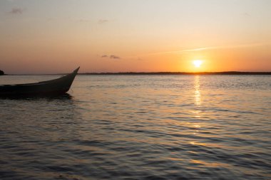 Nehirde teknesi olan güzel bir gün batımı