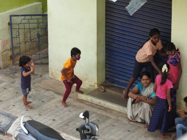 Bangalore, Karnataka, Hindistan-Mayıs 04-2021: Şehirde oynayan, dans eden ve koşan bir grup Hintli çocuk.