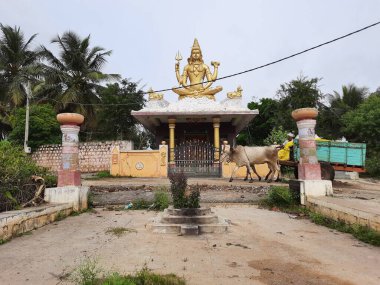 Channapatna, Karnataka, Hindistan-Aug 15 2021: Güzel eski Sri Arkeshwara Tapınağı Altın Renkli Shiva heykelinin yakın çekimi, Bevoor tapınağının tepesinde, Gölet 'in yanında