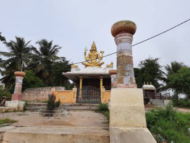 Channapatna, Karnataka, Hindistan-Aug 15 2021: Güzel eski Sri Arkeshwara Tapınağı Altın Renkli Shiva heykelinin yakın çekimi, Bevoor tapınağının tepesinde, Gölet 'in yanında