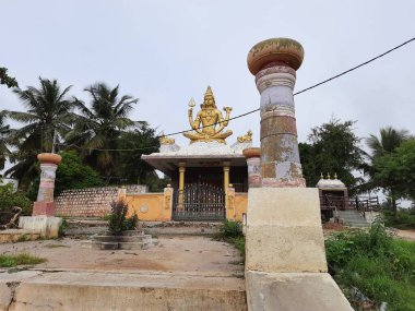 Channapatna, Karnataka, Hindistan-Aug 15 2021: Güzel eski Sri Arkeshwara Tapınağı Altın Renkli Shiva heykelinin yakın çekimi, Bevoor tapınağının tepesinde, Gölet 'in yanında