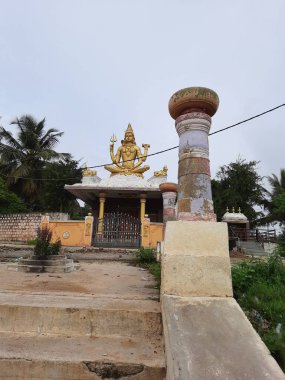 Channapatna, Karnataka, Hindistan-Aug 15 2021: Güzel eski Sri Arkeshwara Tapınağı Altın Renkli Shiva heykelinin yakın çekimi, Bevoor tapınağının tepesinde, Gölet 'in yanında